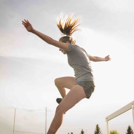 Young Woman Jumping A Hurdle image