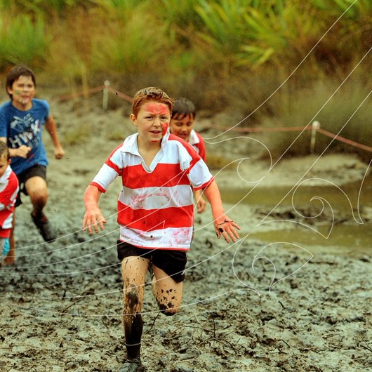 Boys running on a very muddy track image