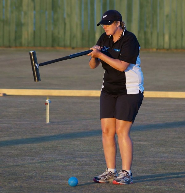 A croquet player lining up a shot