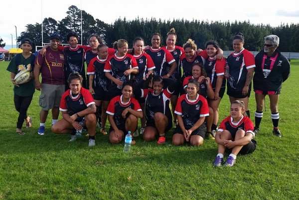 a girls rugby team posing for a photo after a game