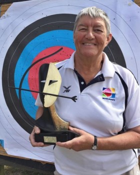 Carole Hicks holding an archery trophy