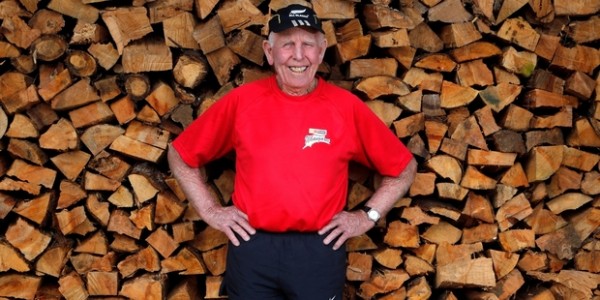 Man standing in front of a log pile