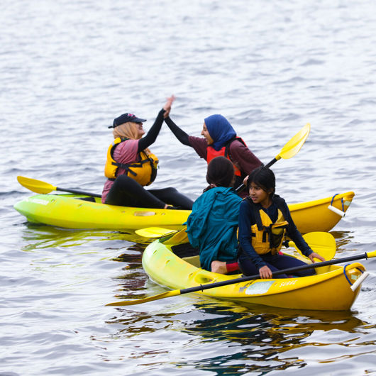 Four rangatahi in kayaks