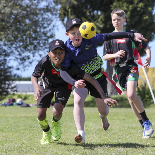 Three boys hustling to get control of a ball image