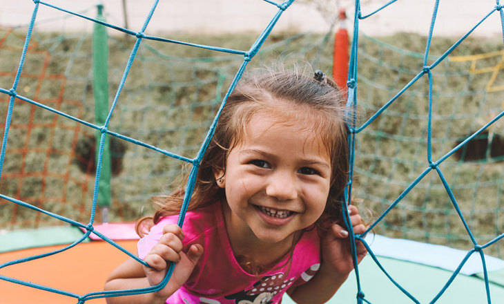 Girl playing on climbing net