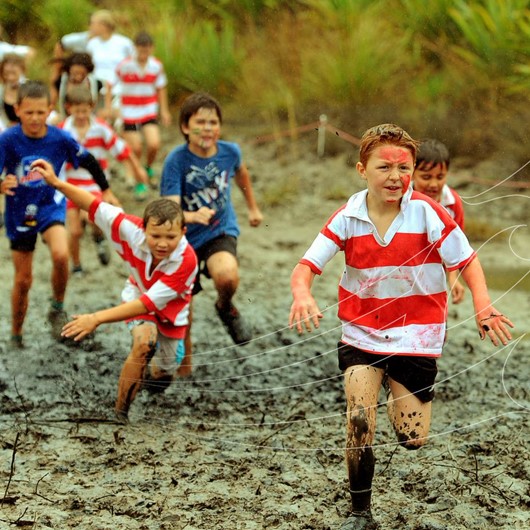 Boys running on a very muddy track