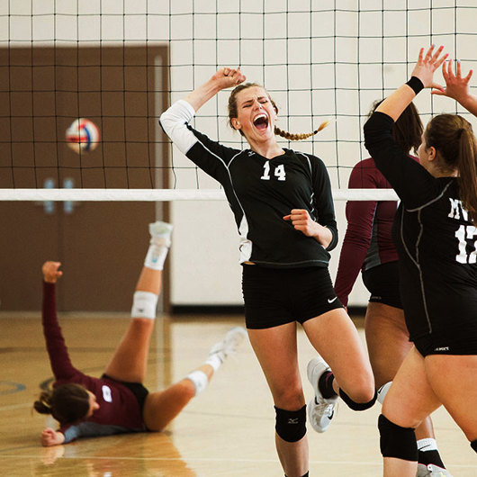 Volleyballers high five after winning a point