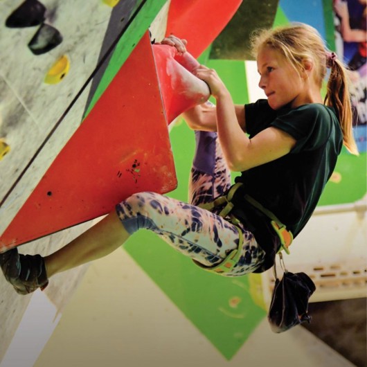 Girl scaling a climbing wall