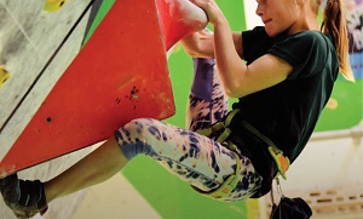 Girl scaling a climbing wall