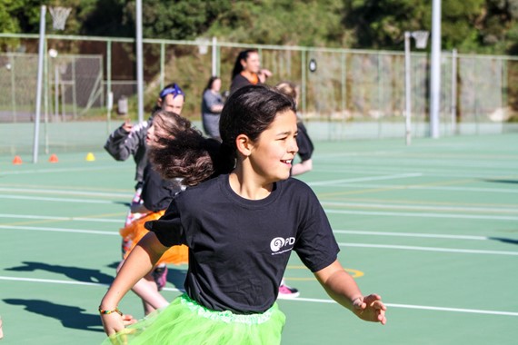 a young netball player running on a court