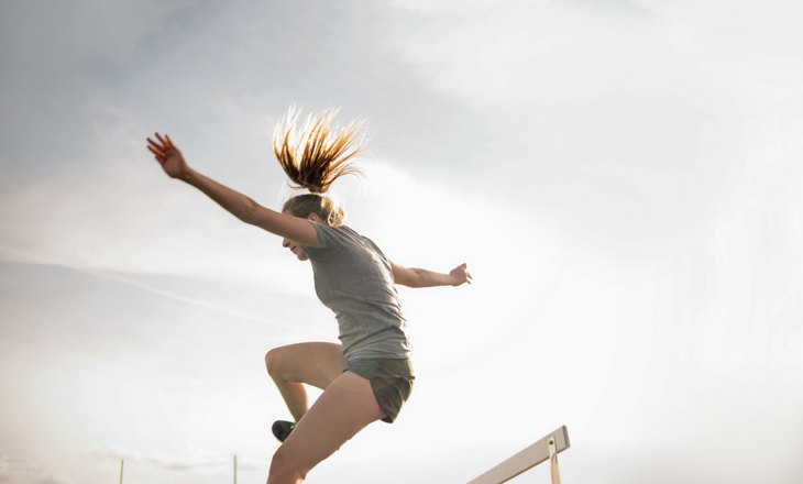 Girl jumping hurdles