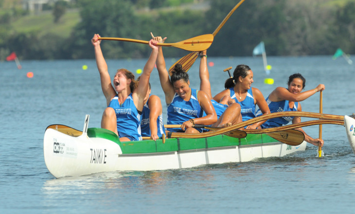 Girls celebrate winning a race in a waka