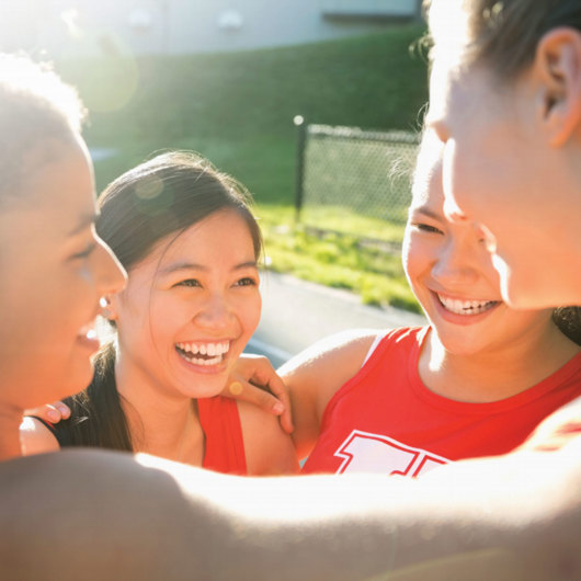 Stock image of team huddled and smiling image