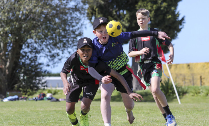 Three boys playing ki-o-rahi