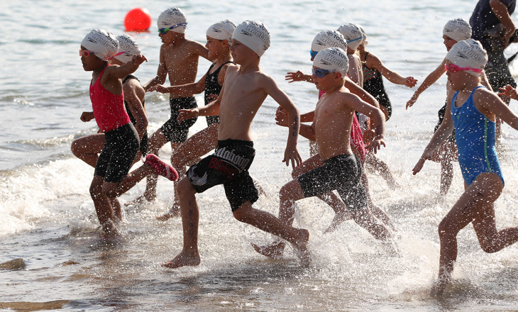 Young swimmers racers running towards the water