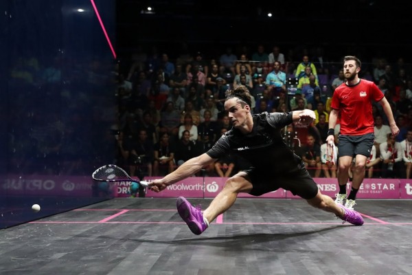 Paul Coll playing squash reaching for the ball