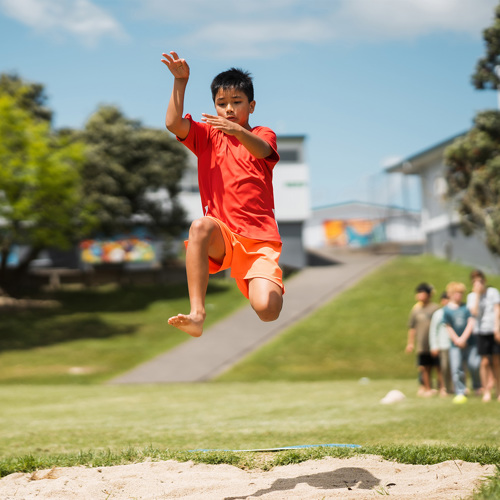 tamariki doing a long jump