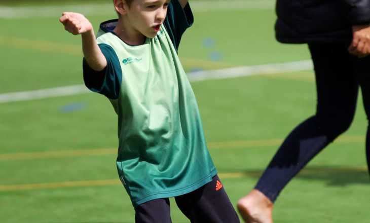 Boy raises both arms on a court