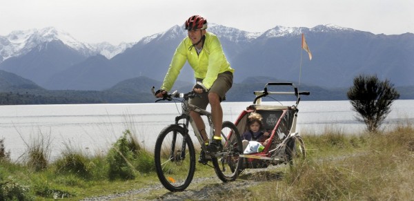 cyclist with baby carrier behind bike