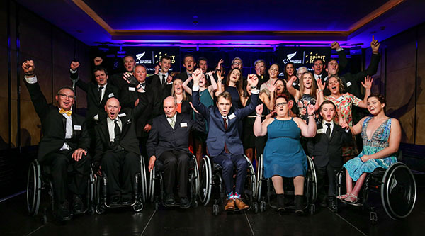 Paralympics NZ posing as a group with their arms raised in celebration
