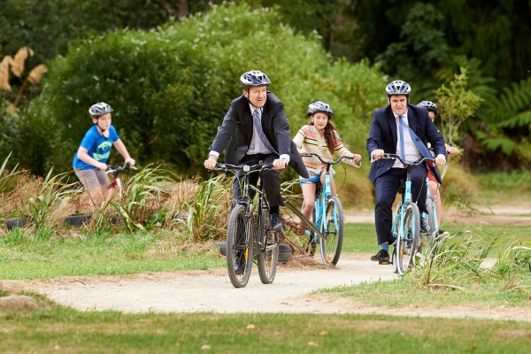 Two ministers and three teenagers cycling through a park