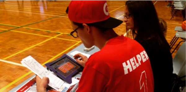 volunteer entering game information into a tablet
