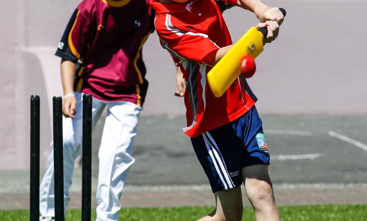 Boys on a field playing cricket