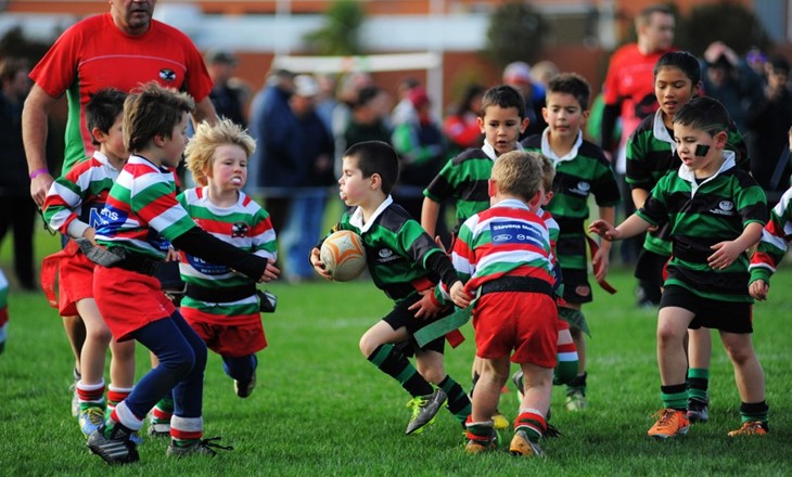 Young boys playing a game of ripper rugby on a field