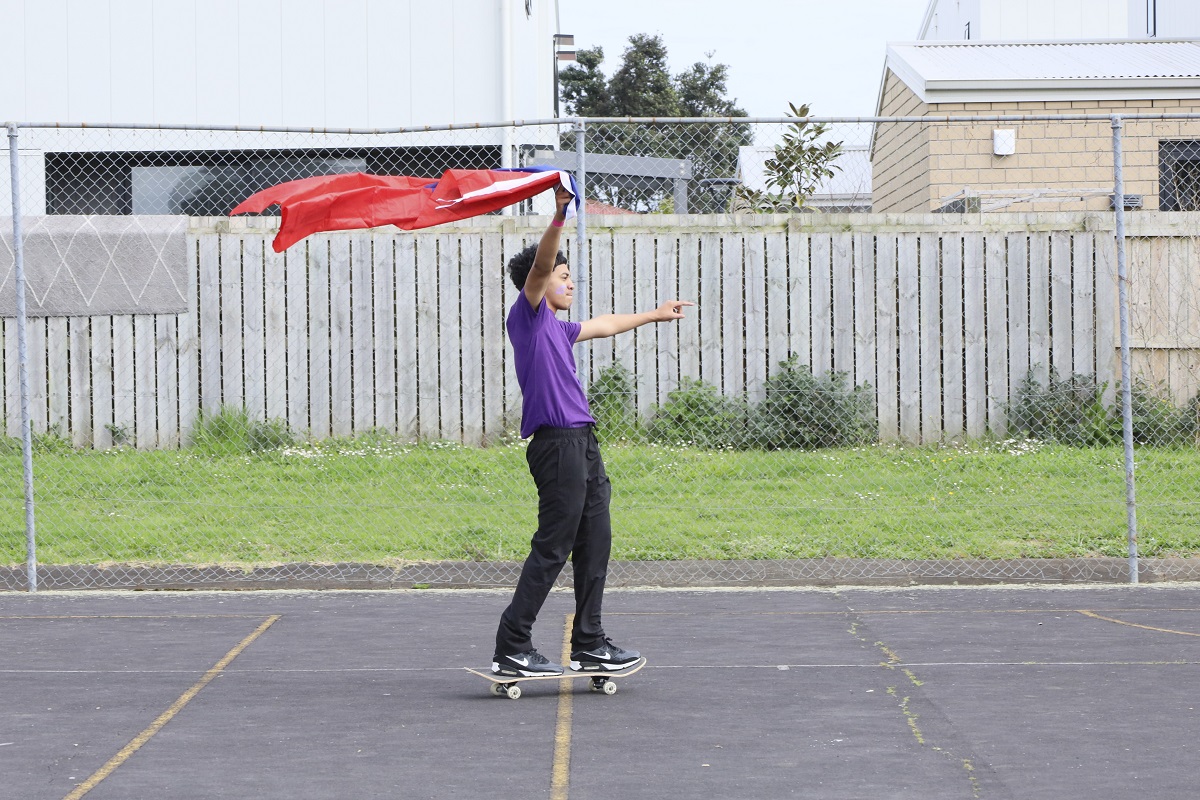 Boy on a skateboard holding a red flag