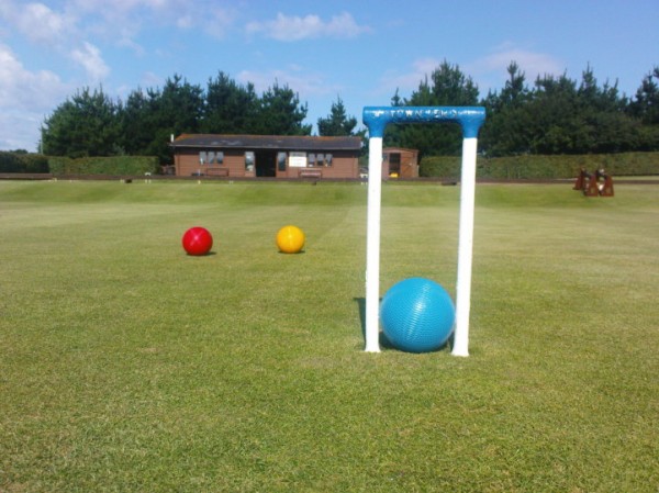 looking through a croquet pin to two balls in the distance