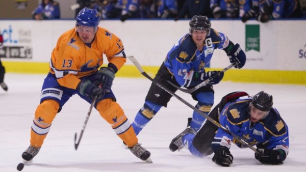 Three players playing icehockey