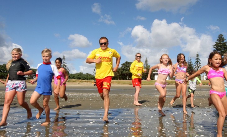 Lifeguards and children running into the surf