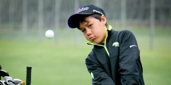 Young boy chipping a golf ball