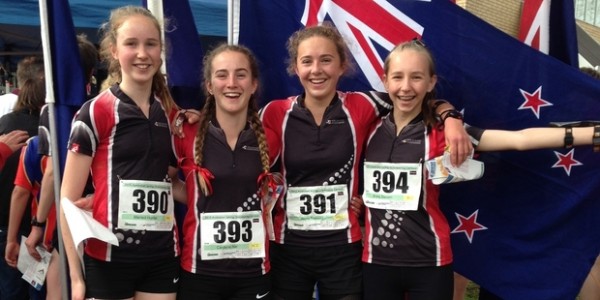 Orienteering team standing in front of the NZ flag