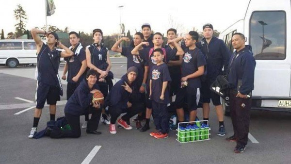 a young basketball team posing for a photo in a carpark