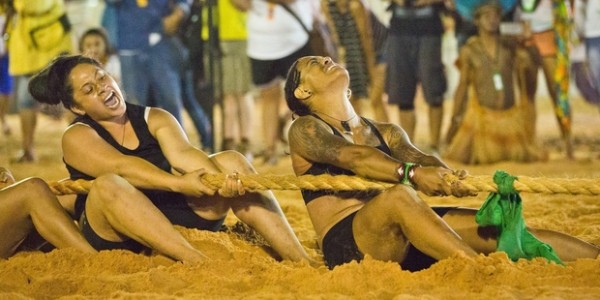 Young women playing tug of war on a beach