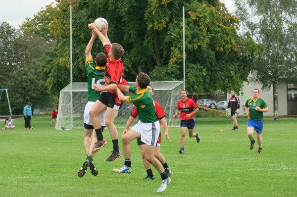 Gaelic football players reaching for a ball