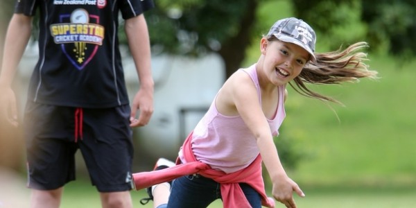 Young smiling girl throwing a ball