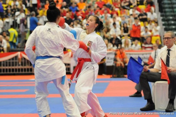 Two women in a karate competition with a judge to the right side