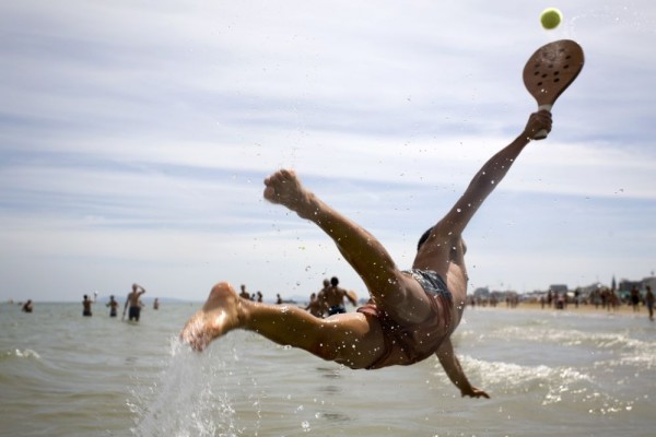 man diving for a ball at the beach 