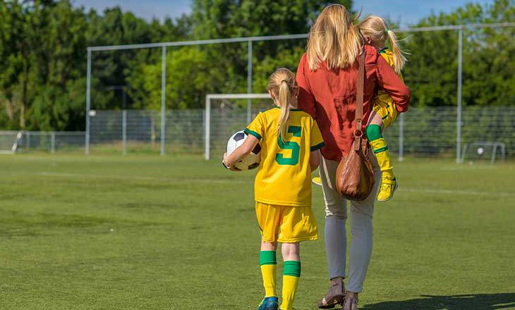 Soccer Mom accompanying her 2 daughters to football training