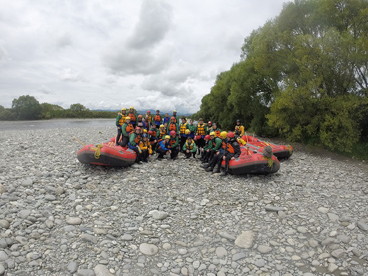 Group pose on river bank with inflatables