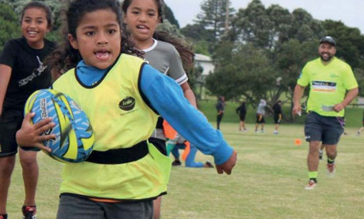 Tamariki breaking away with a rugby ball