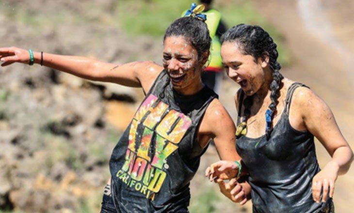 Two girls partaking in a muddy challenge