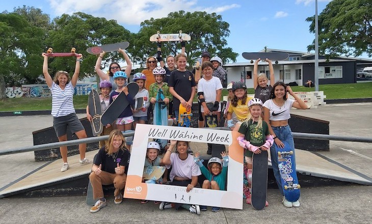 Group of young women holding up signs at skate park