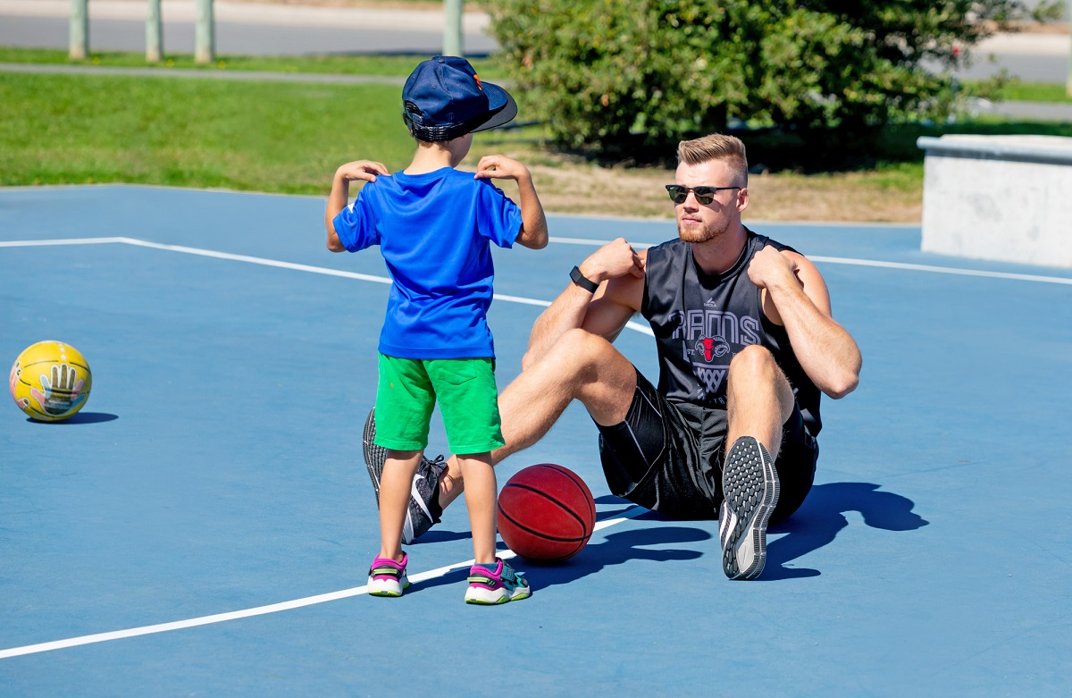 Child and Rams player with their hands on own shoulders