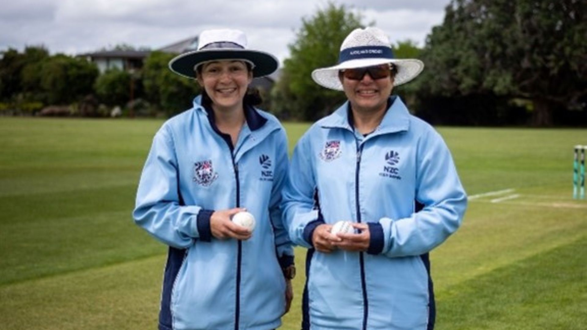 Two women holding cricket balls