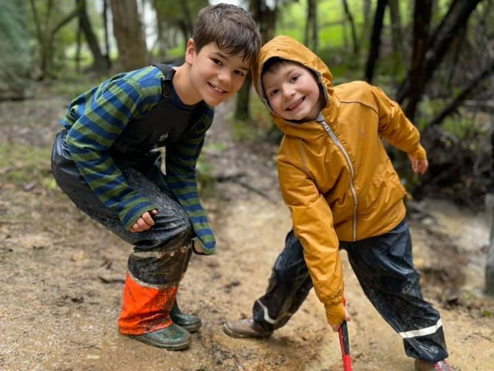 Two kids playing in mud