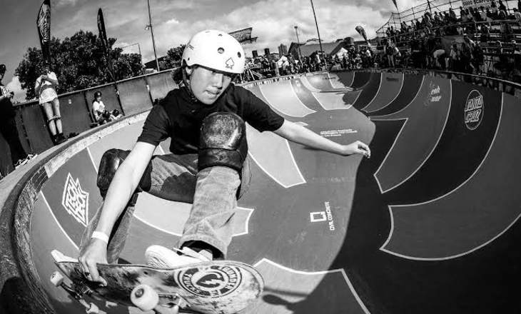 Girl doing skateboard tricks at a skate park