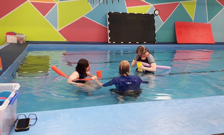 three people in a pool